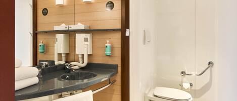 A modern bathroom with a curved sink, a toilet, and a shower area.