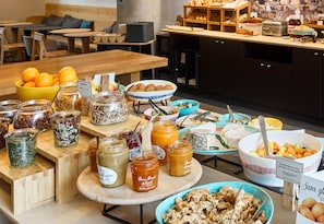 A buffet with various food items including fruits, nuts, and spreads. - B&B HOME Paris Nord 18ème (Paris)