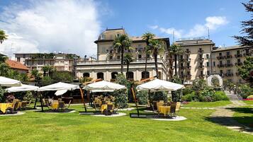 A hotel courtyard with outdoor seating and a large building in the background.