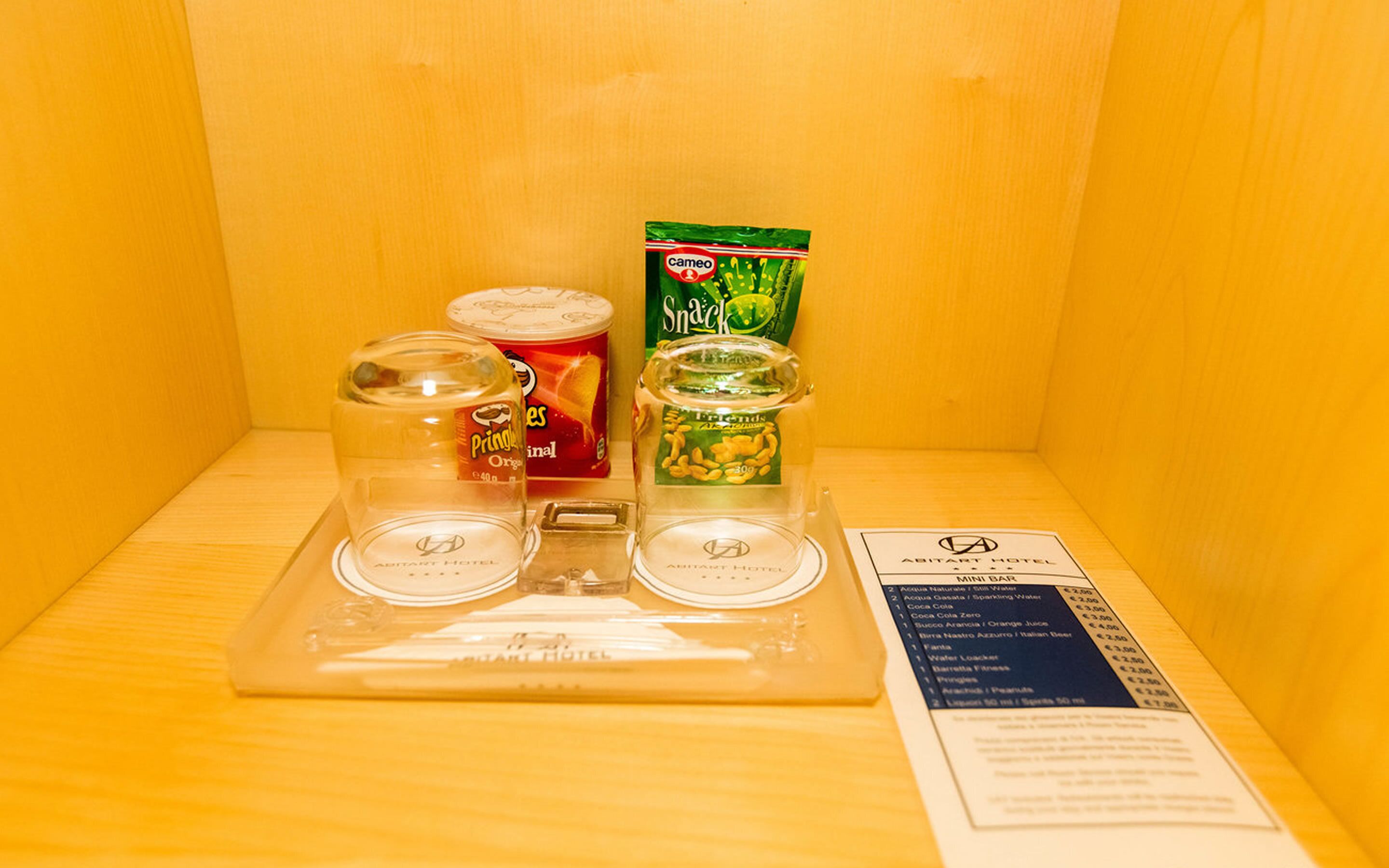 Eine Minibar mit Snacks, Getränken und einer Speisekarte.