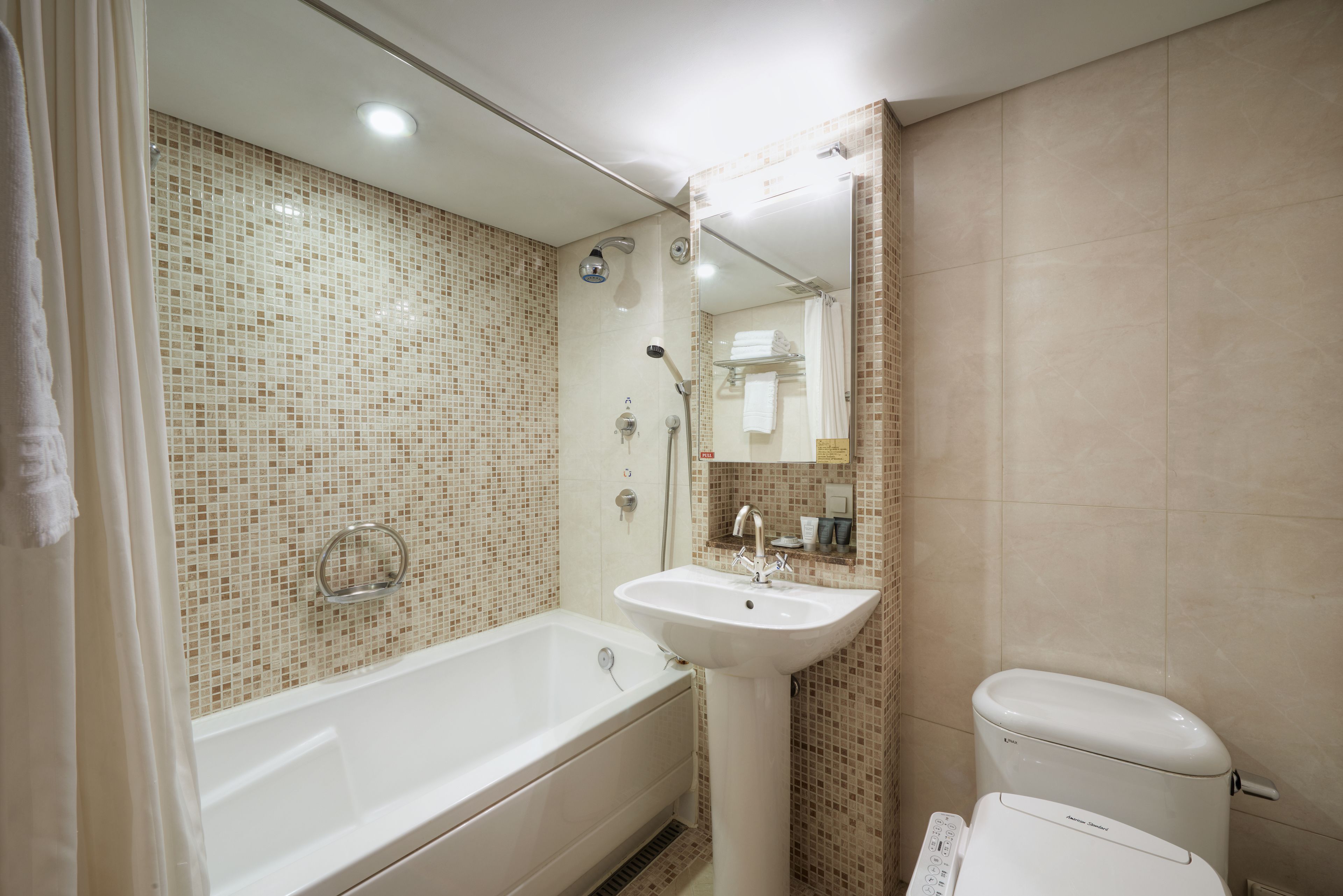 A modern bathroom with a bathtub, a sink, and a toilet.