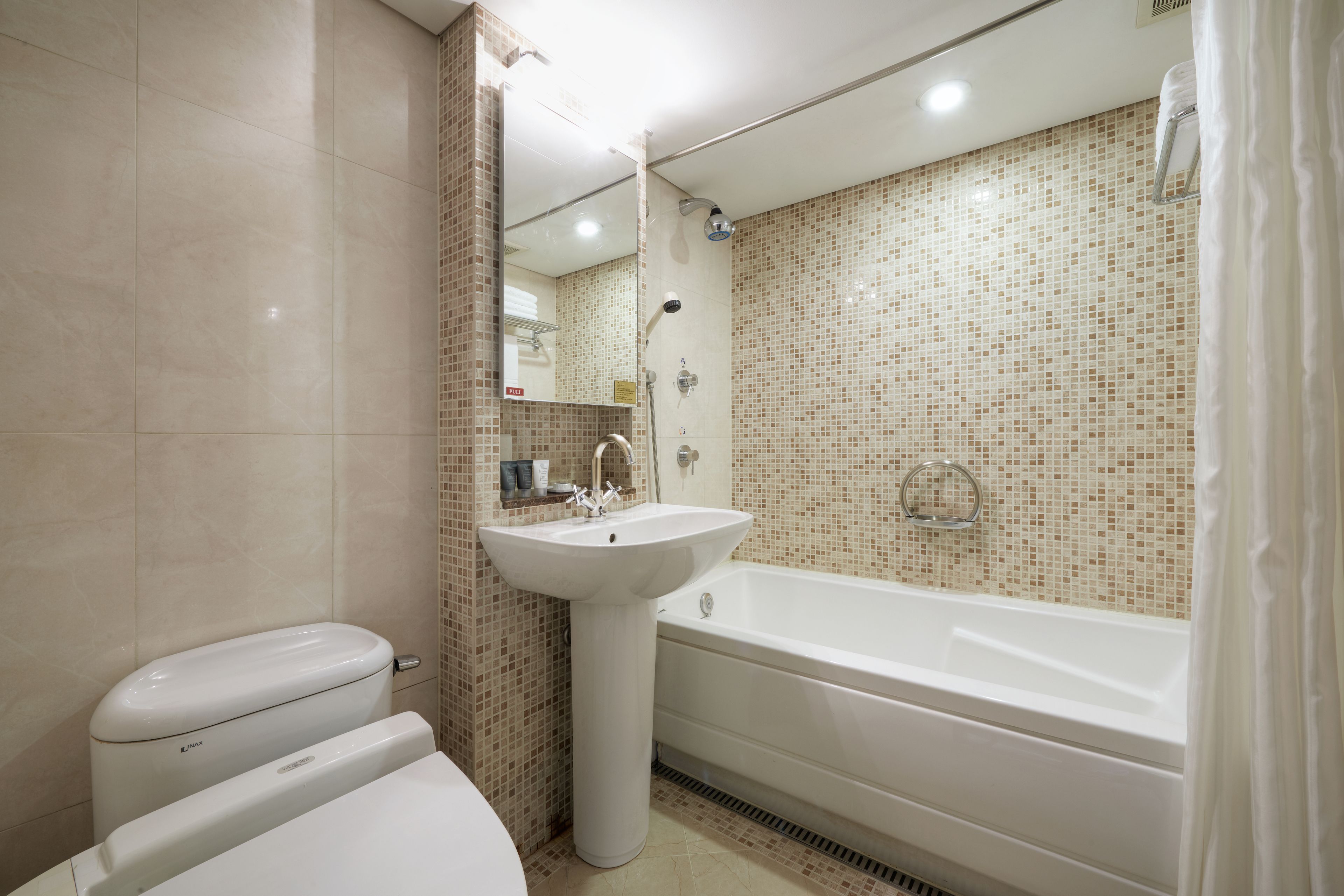 Un baño moderno con inodoro, lavabo y bañera.