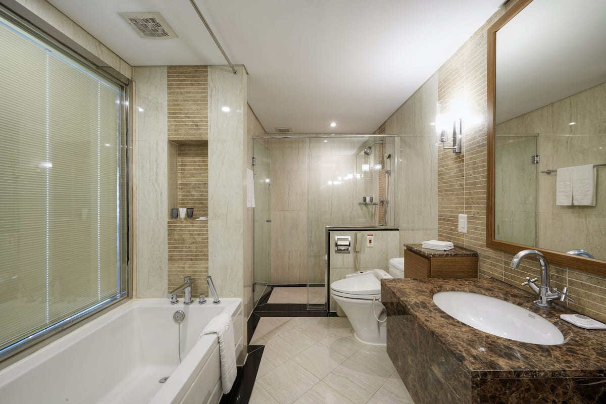 A modern bathroom with a bathtub, toilet, and sink.