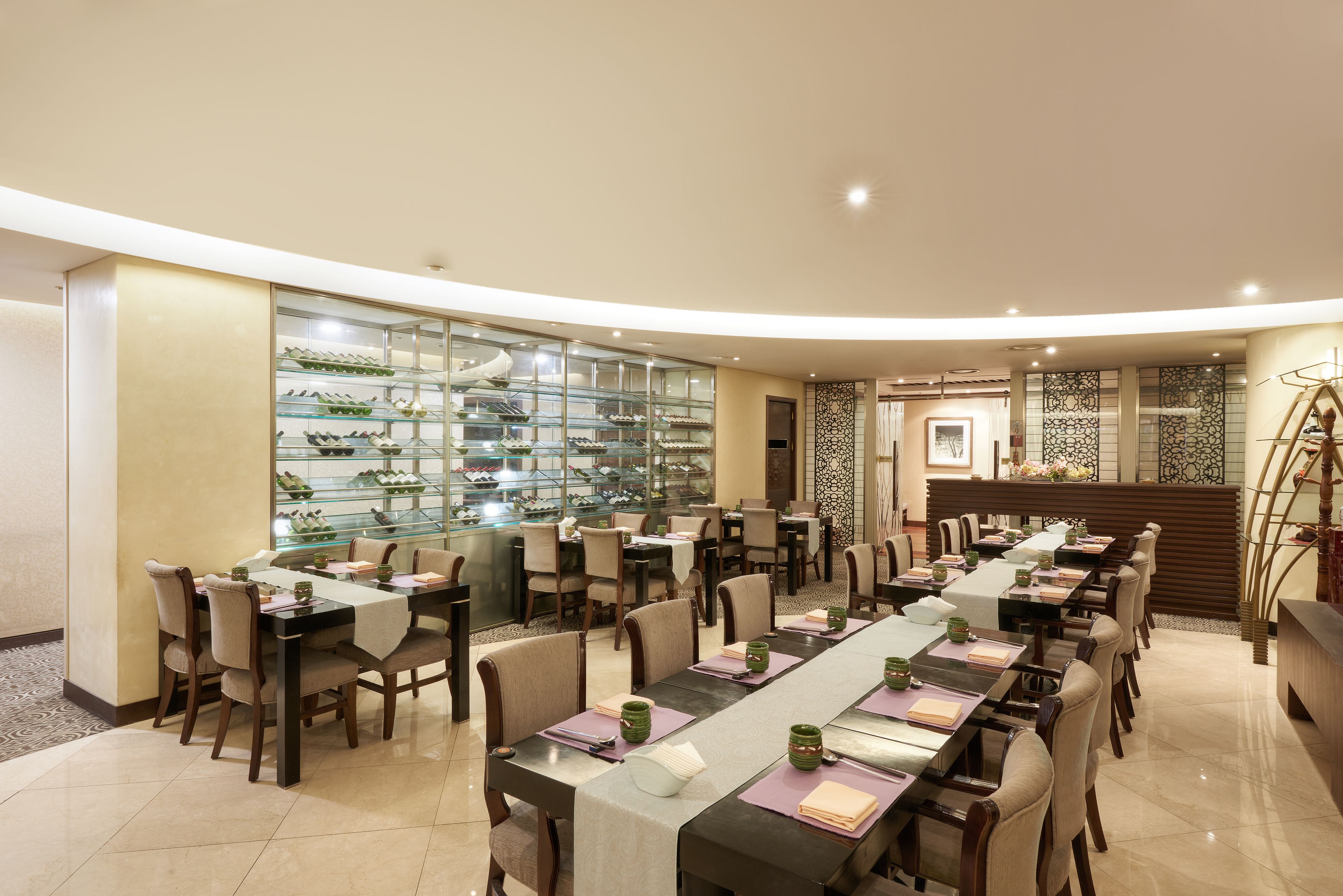 A spacious dining area with multiple tables and chairs, a display of shoes on the left, and a staircase leading to an upper level.