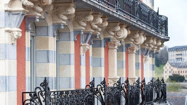A building with ornate balconies and classical architectural details. - Grand Hotel Moderne (Lourdes)
