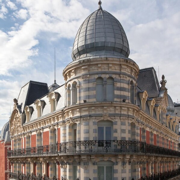 Un edificio histórico con una cúpula destacada y detalles arquitectónicos ornamentales.