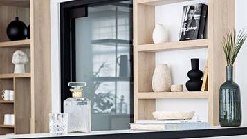 Un intérieur moderne avec une porte en verre, des étagères en bois et des objets décoratifs.