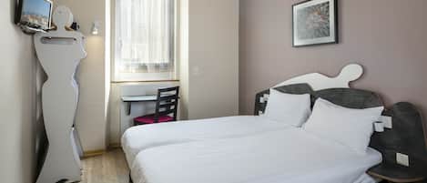A hotel room with a bed, a desk, a chair, a television, and a picture on the wall.