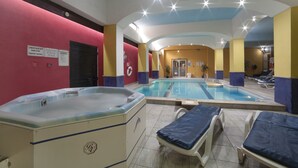 Een zwembadgedeelte met een jacuzzi, ligbedden en een douchegedeelte.