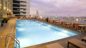 A rooftop pool with a view of the city skyline and a body of water. - Carlton Tower Hotel (Dubai)