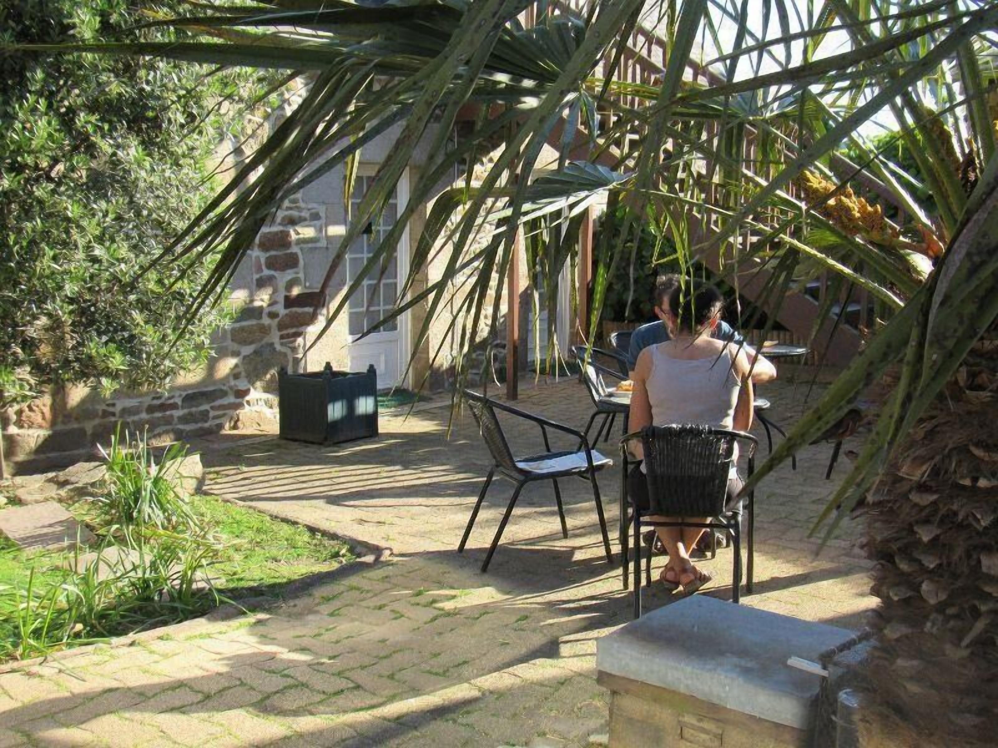 Een terras met stenen vloer, tuinmeubilair en een stenen muur.