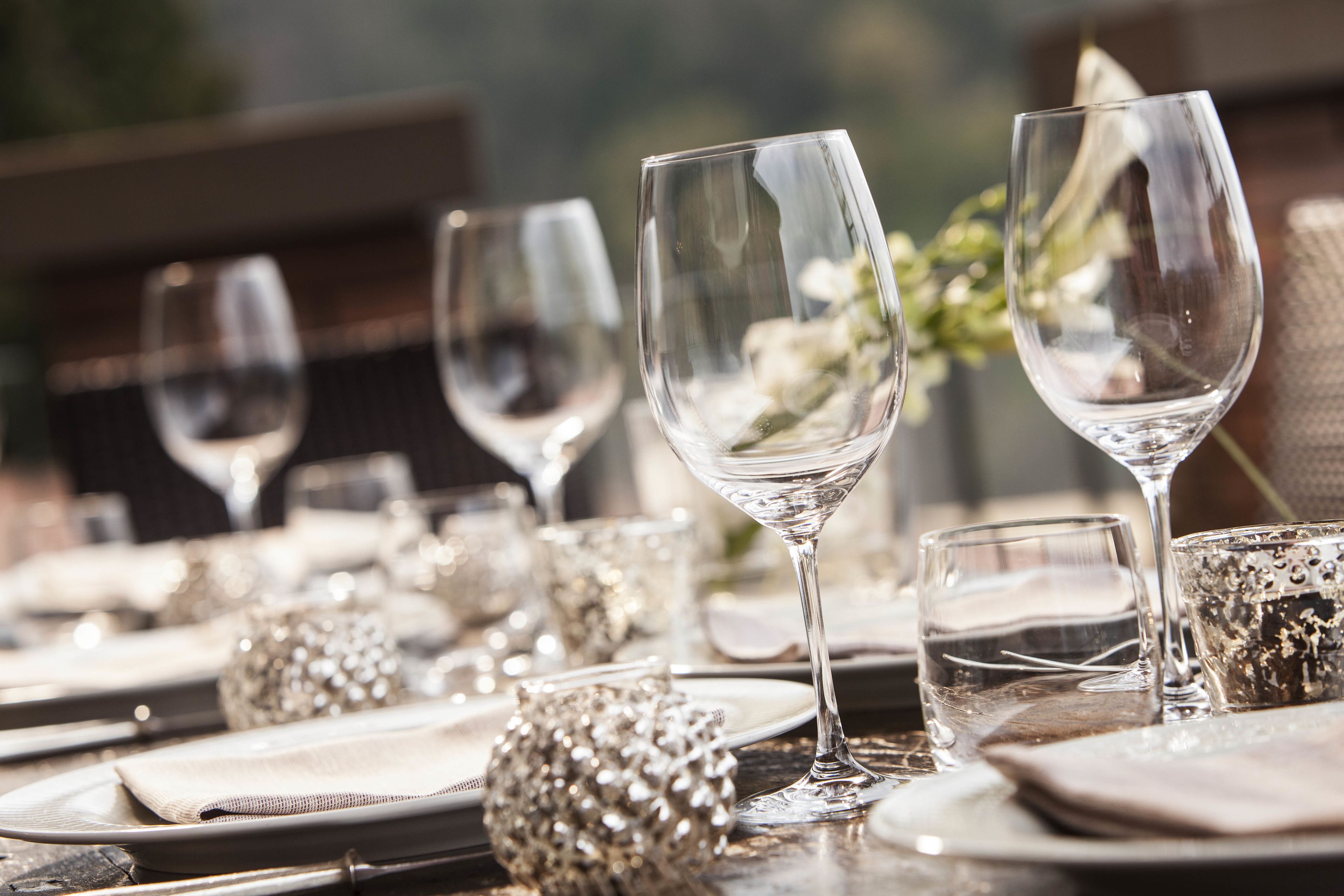 A table set for a formal dining occasion with clear glassware and silverware.