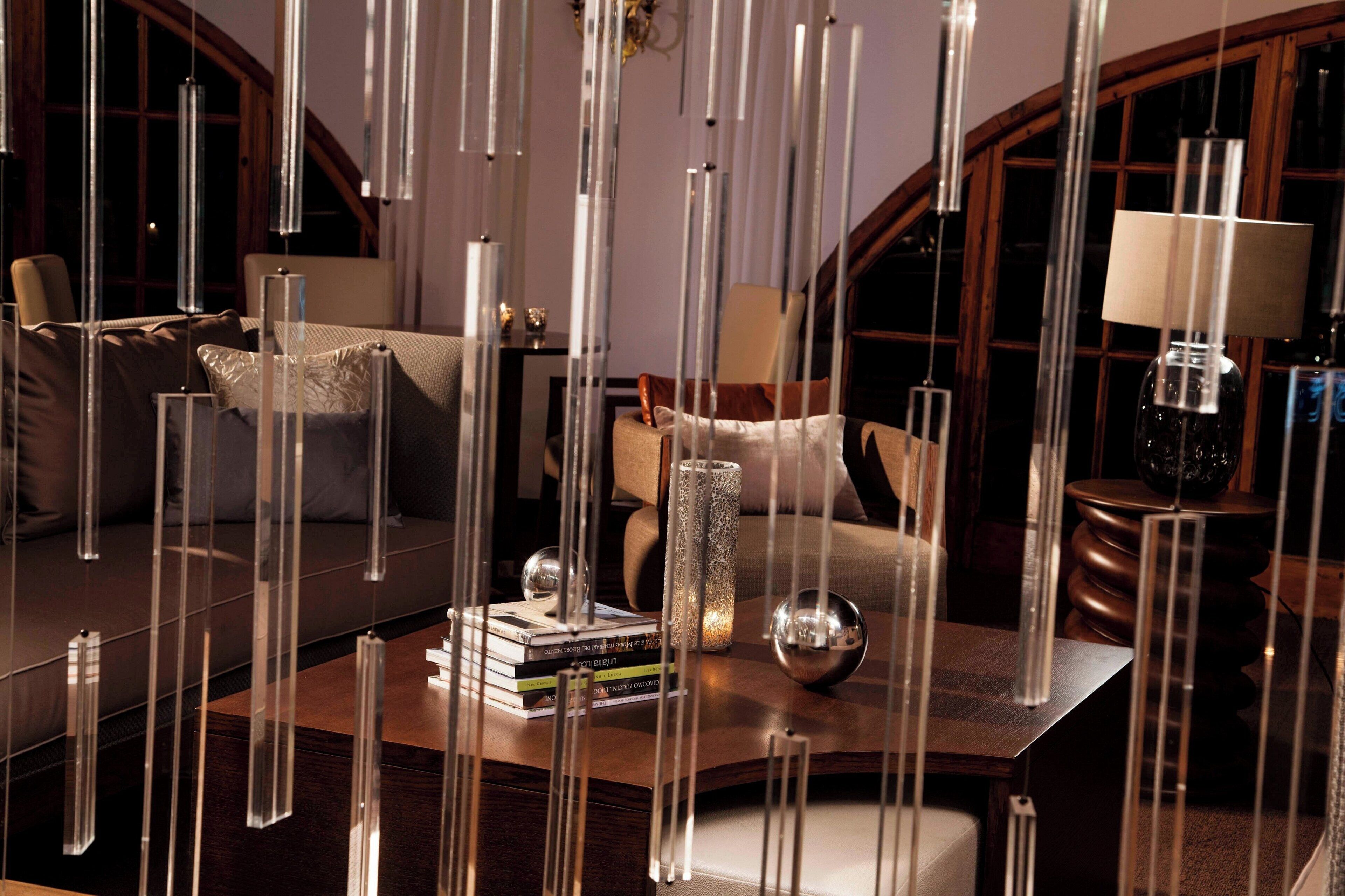 A modern living room with a sofa, a coffee table with books and decorative items, and a lamp.