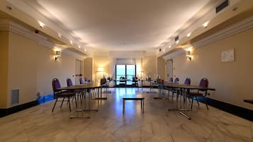 Una sala de conferències amb una taula llarga, cadires i una banca.