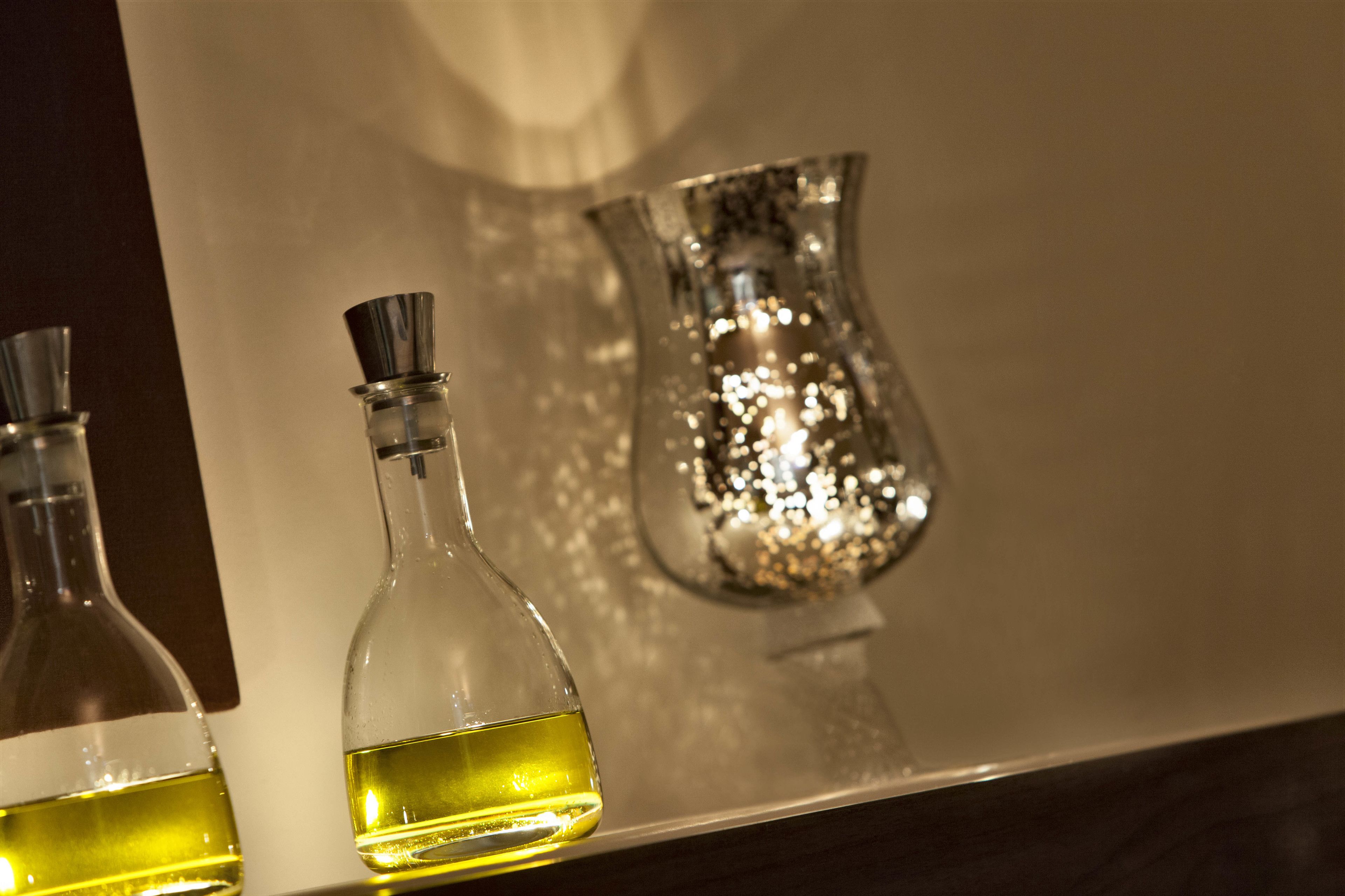 Dos botellas de vidrio con líquido sobre una superficie reflectante.