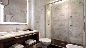 Une salle de bain moderne avec un meuble-lavabo en marbre, des toilettes, une douche à parois de verre et un grand miroir.