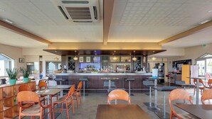 A modern restaurant interior with a bar area, wooden chairs, and a counter with various items. - Golf de St Samson (Pleumeur-Bodou)