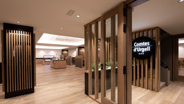 Un interior moderno con suelo de madera, una zona de recepción y un letrero que dice "Comtes d'Urgell".