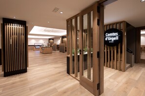 Un interior moderno con suelo de madera, una zona de recepción y un letrero que dice "Comtes d'Urgell".