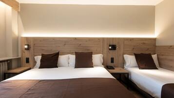 Una habitación doble con una cama grande, dos mesitas de noche y un cabecero de madera.