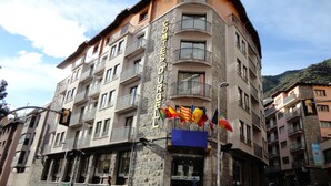 Un hotel de varios pisos con balcones y fachada de piedra.