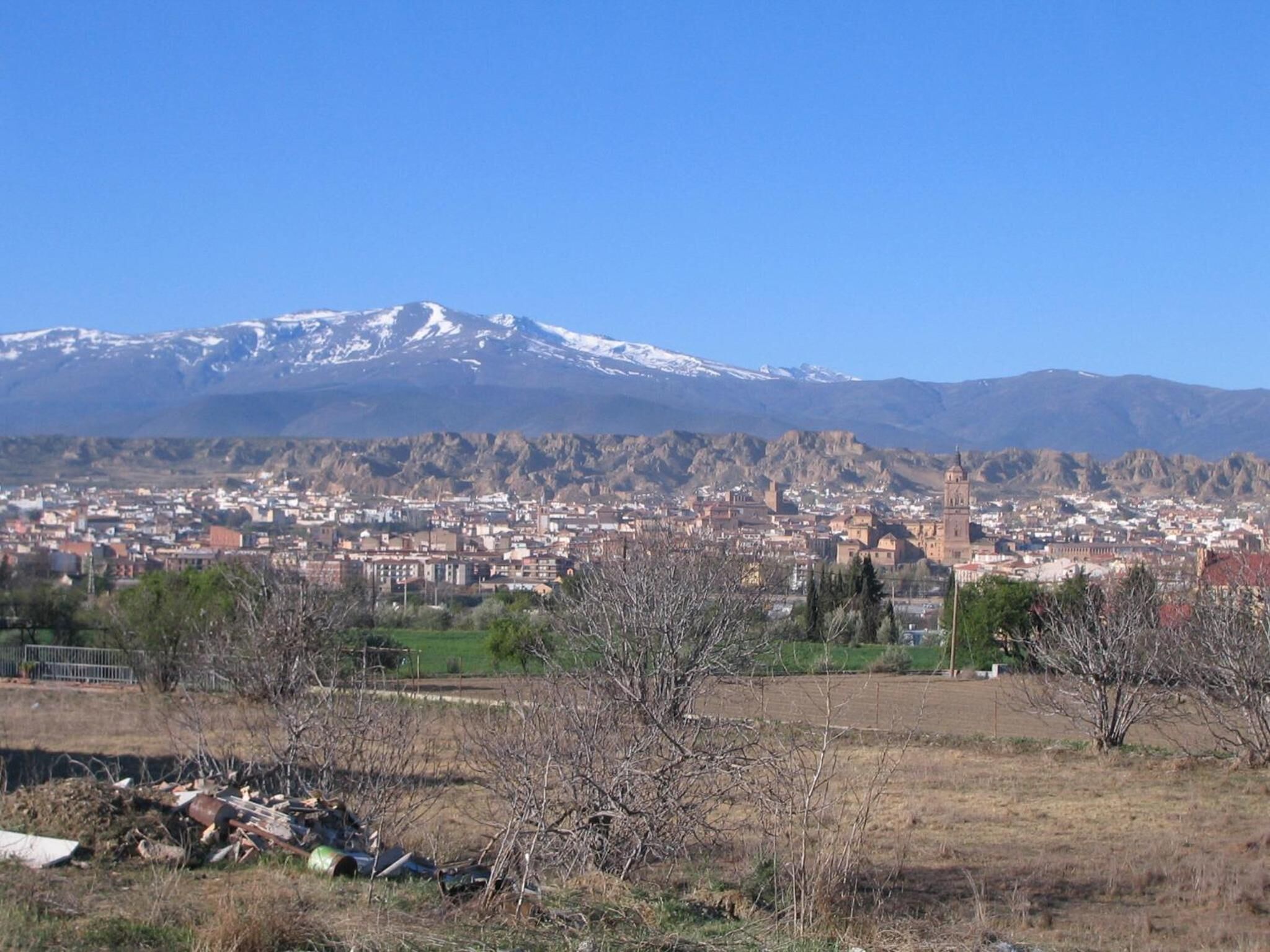 Une ville qui se distingue par son église imposante et par une montagne enneigée qui se profile à l’arrière-plan.