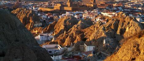 A town with a prominent castle-like structure surrounded by rugged terrain.