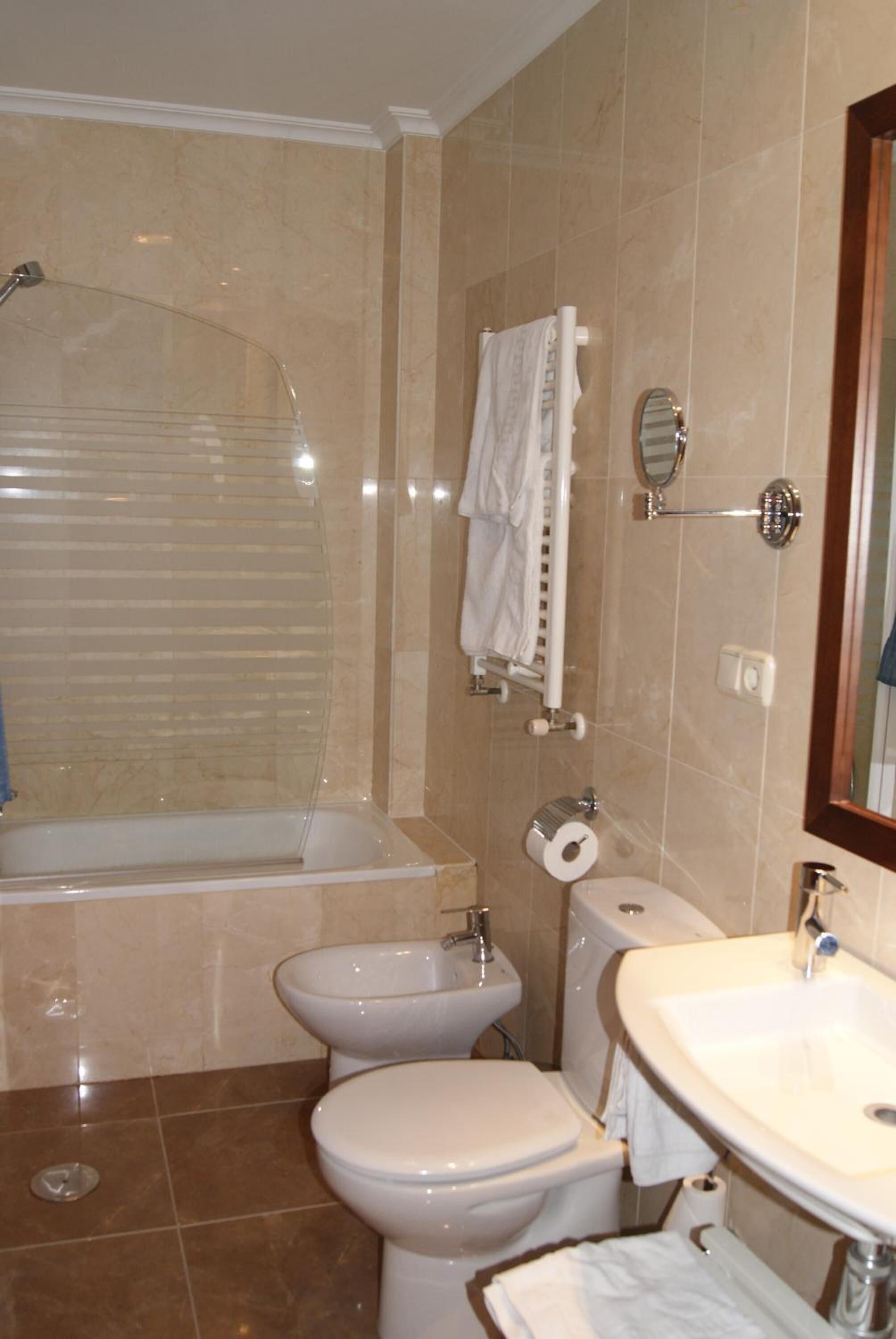 Un baño con bañera, inodoro, bidé y lavamanos.