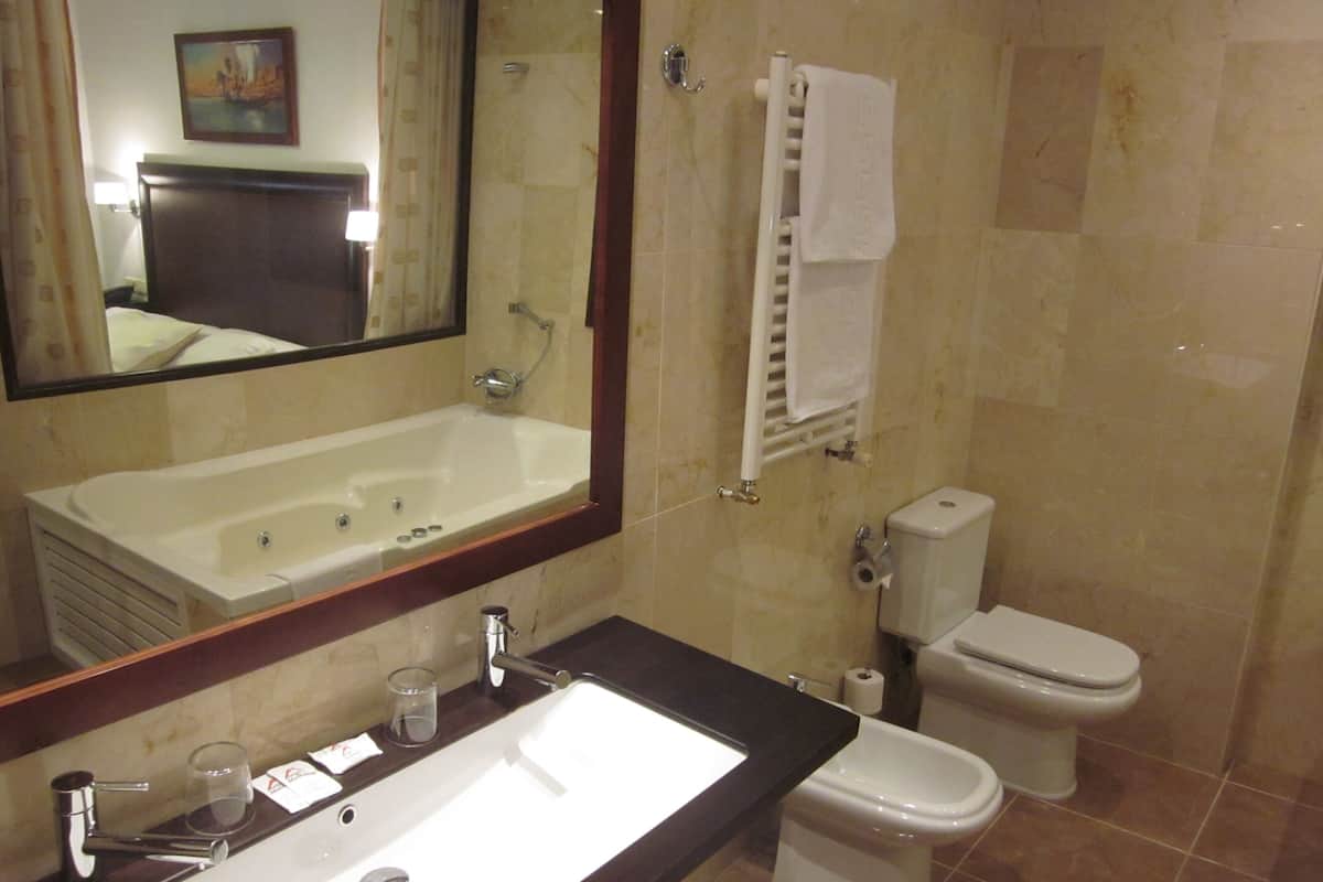 Ein Badezimmer mit Badewanne, Waschbecken, Toilette und Handtuchhalter.