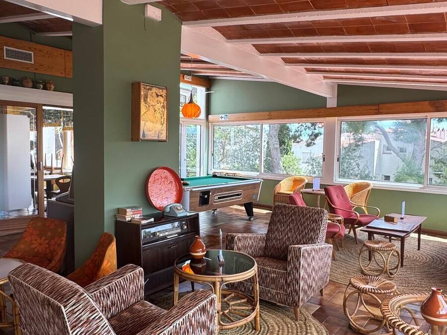 A cozy room with wicker furniture, a pool table, and a view of the outdoors.