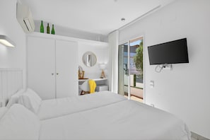 Een slaapkamer met een bed, een bureau, een stoel, een spiegel en een televisie.