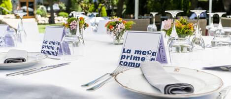 Una mesa dispuesta para una comida, con tarjetas de lugar, vasos y cubiertos.