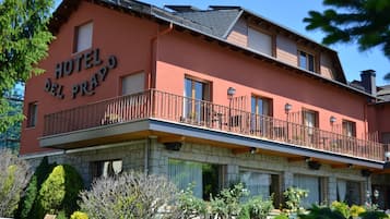 Un edificio de dos pisos con un balcón, que dice "HOTEL DEL PRADO".