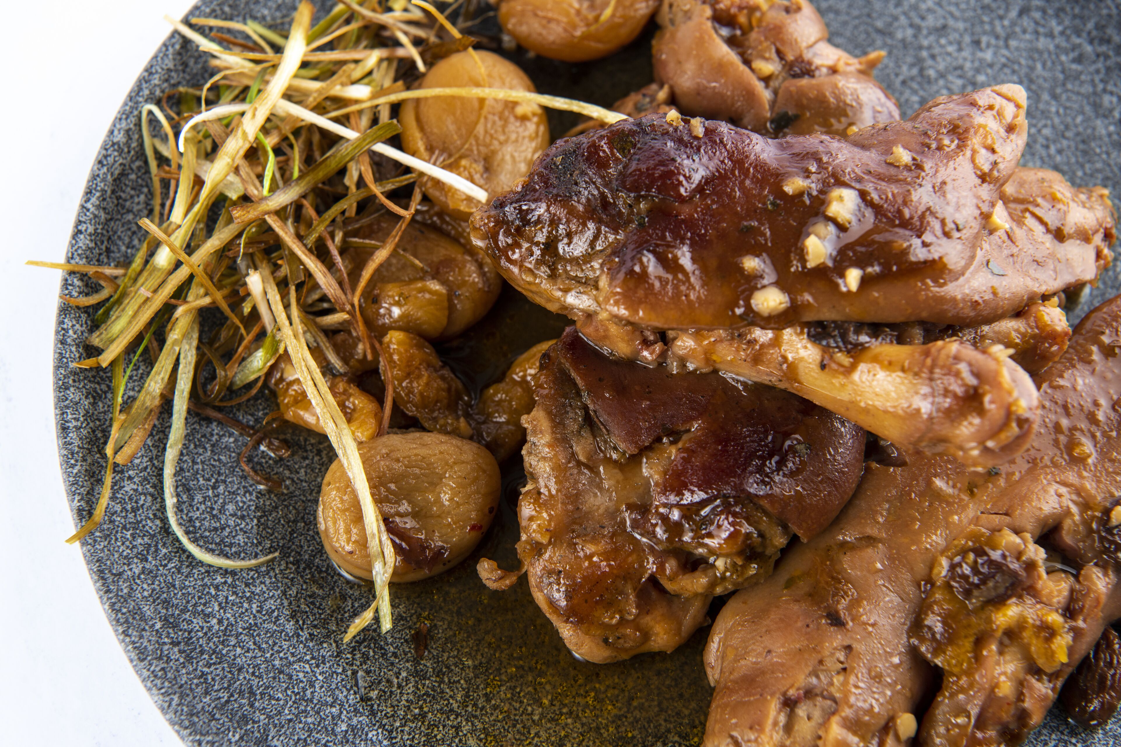 A plate with various food items including meat, mushrooms, and some green garnish.