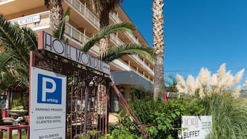 A hotel entrance with a sign indicating private parking for hotel guests.