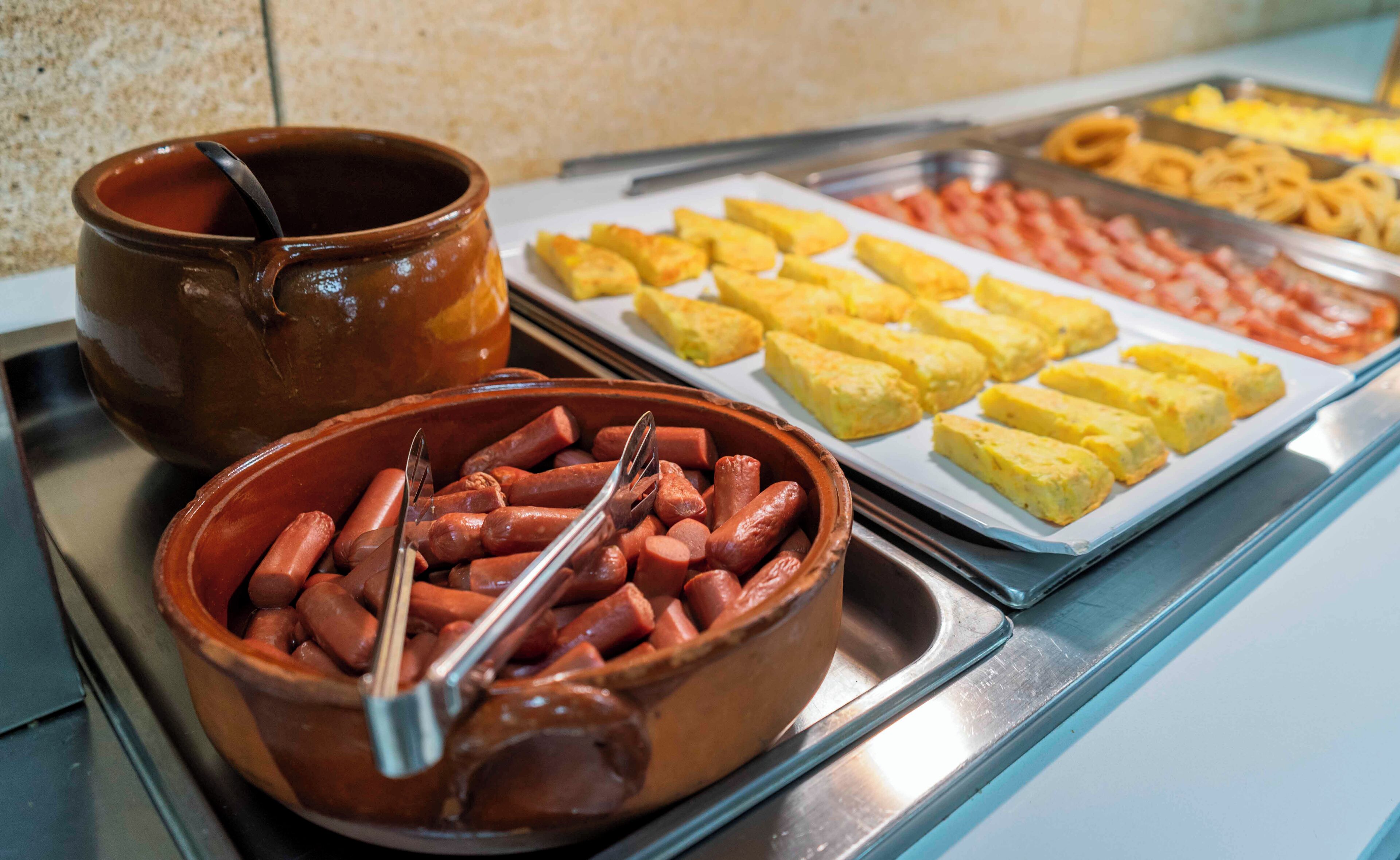 Un buffet proposant des hot-dogs, des frites et d’autres plats.