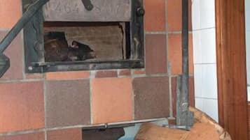 A tiled wall with a metal bracket and a small opening.