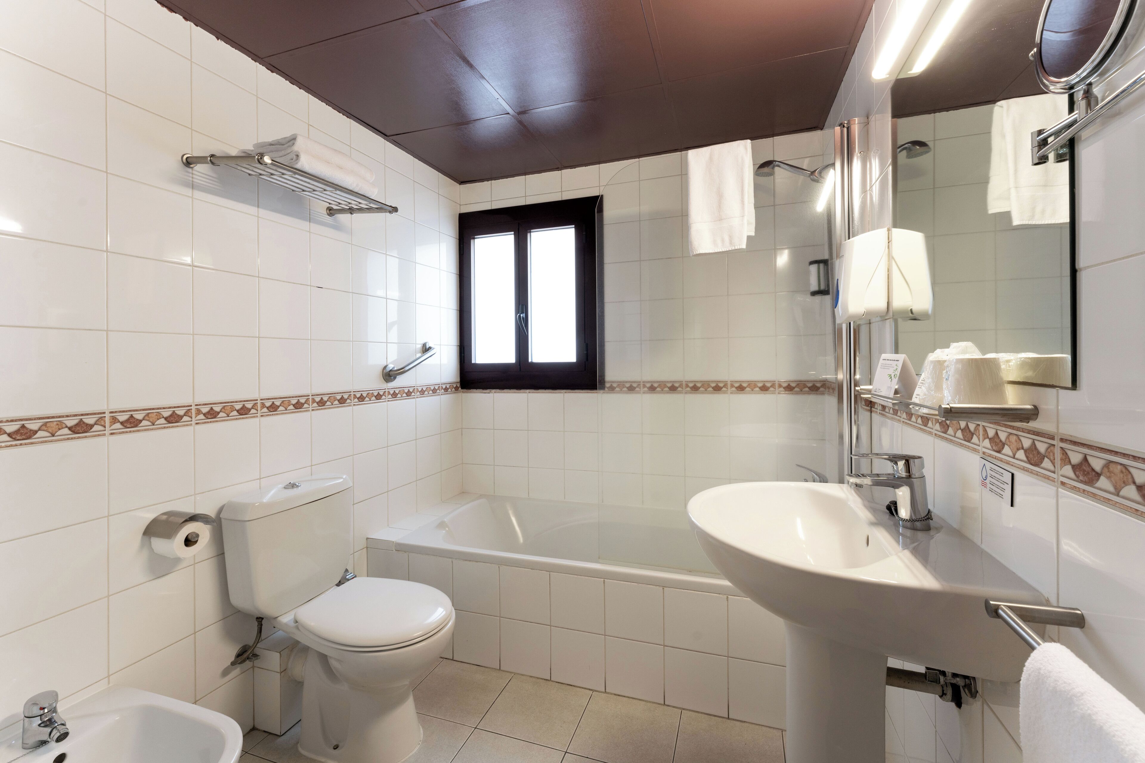 Ein Badezimmer mit Toilette, Bidet, Badewanne und Waschbecken.