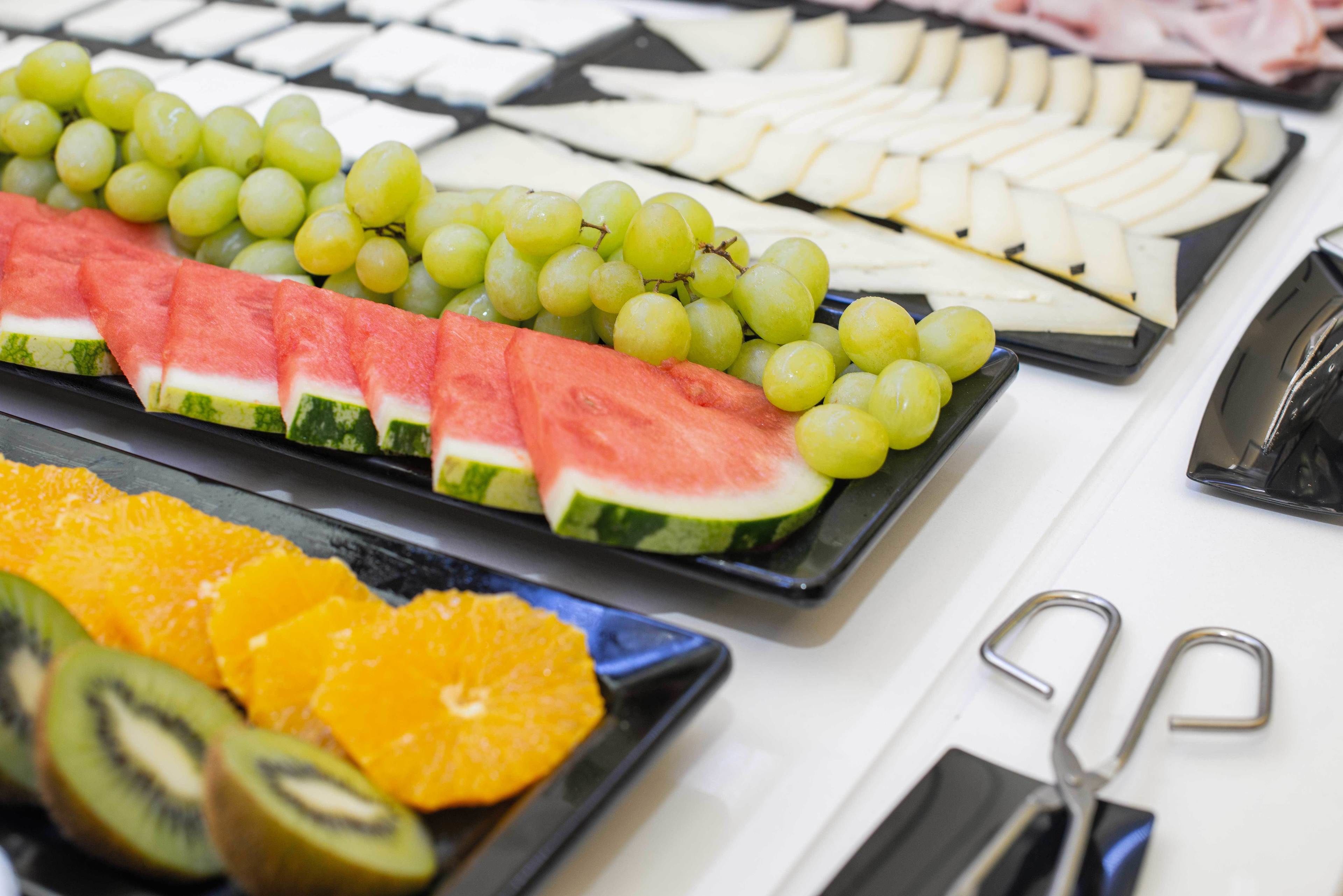 Une variété de fruits et de fromages sont disposés sur une table.