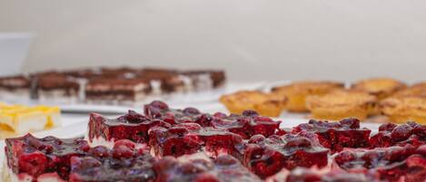 Una variedad de postres, incluyendo pasteles y dulces con frutos rojos.