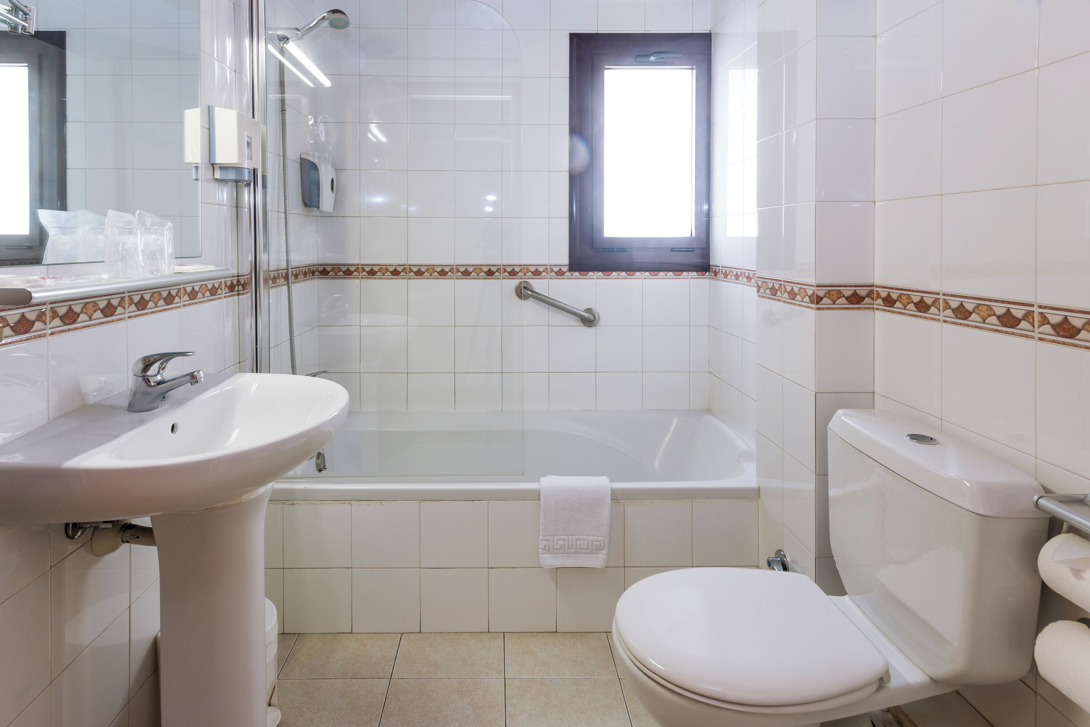 Ein Badezimmer mit Badewanne, Toilette, Waschbecken und einem Fenster.