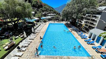 Relax by the pool surrounded by lush greenery and mountain views.