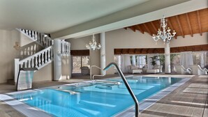 A swimming pool with a modern design, a staircase with white balustrades, and a chandelier. - Hotel & SPA Bringué (El Serrat)