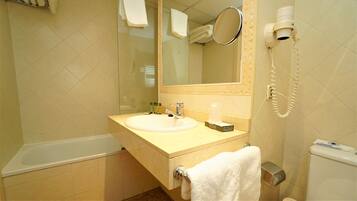 A bathroom with a sink, mirror, towel rack, and a hairdryer.