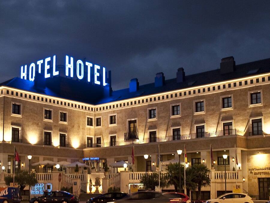 A hotel with a prominent "HOTEL HOTEL" sign, multiple balconies, and a well-lit facade.