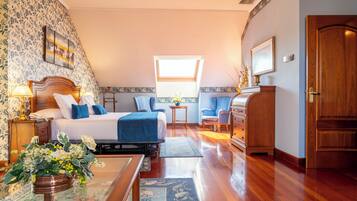 A bedroom with a bed, bedside tables, a desk, a chair, a dresser, a window, and a door.