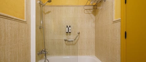 A bathroom with a bathtub, a shower, and a towel rack.
