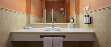 Un baño con un lavabo blanco, un espejo y un perchero para toallas.