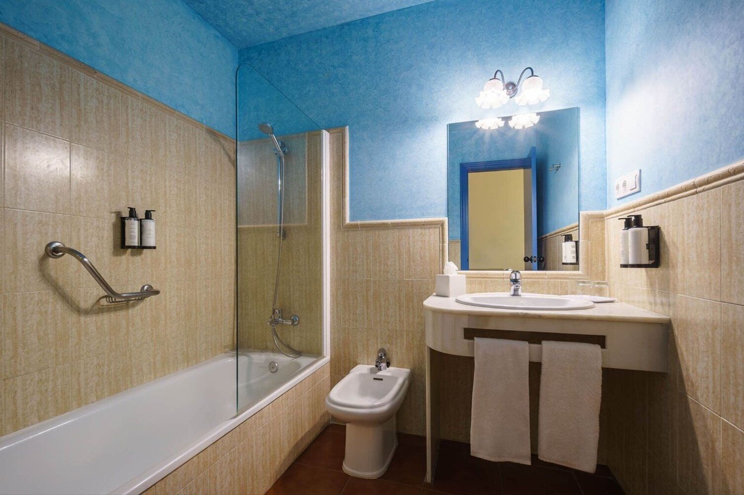 A bathroom with a bathtub, a shower, a toilet, and a sink with a mirror.