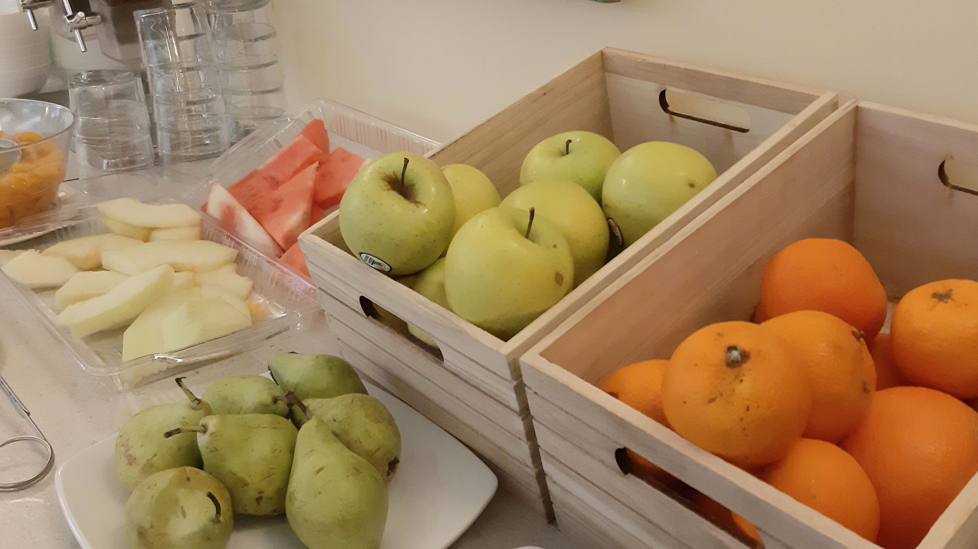 Fruitpresentatie met appels, sinaasappels en peren in houten kisten.
